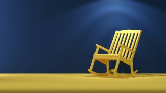 a wooden rocking chair sitting on top of a yellow floor by Mehdi Mirzaie courtesy of Unsplash.