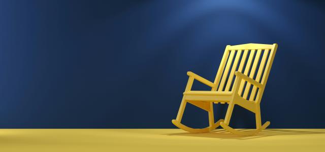 a wooden rocking chair sitting on top of a yellow floor by Mehdi Mirzaie courtesy of Unsplash.